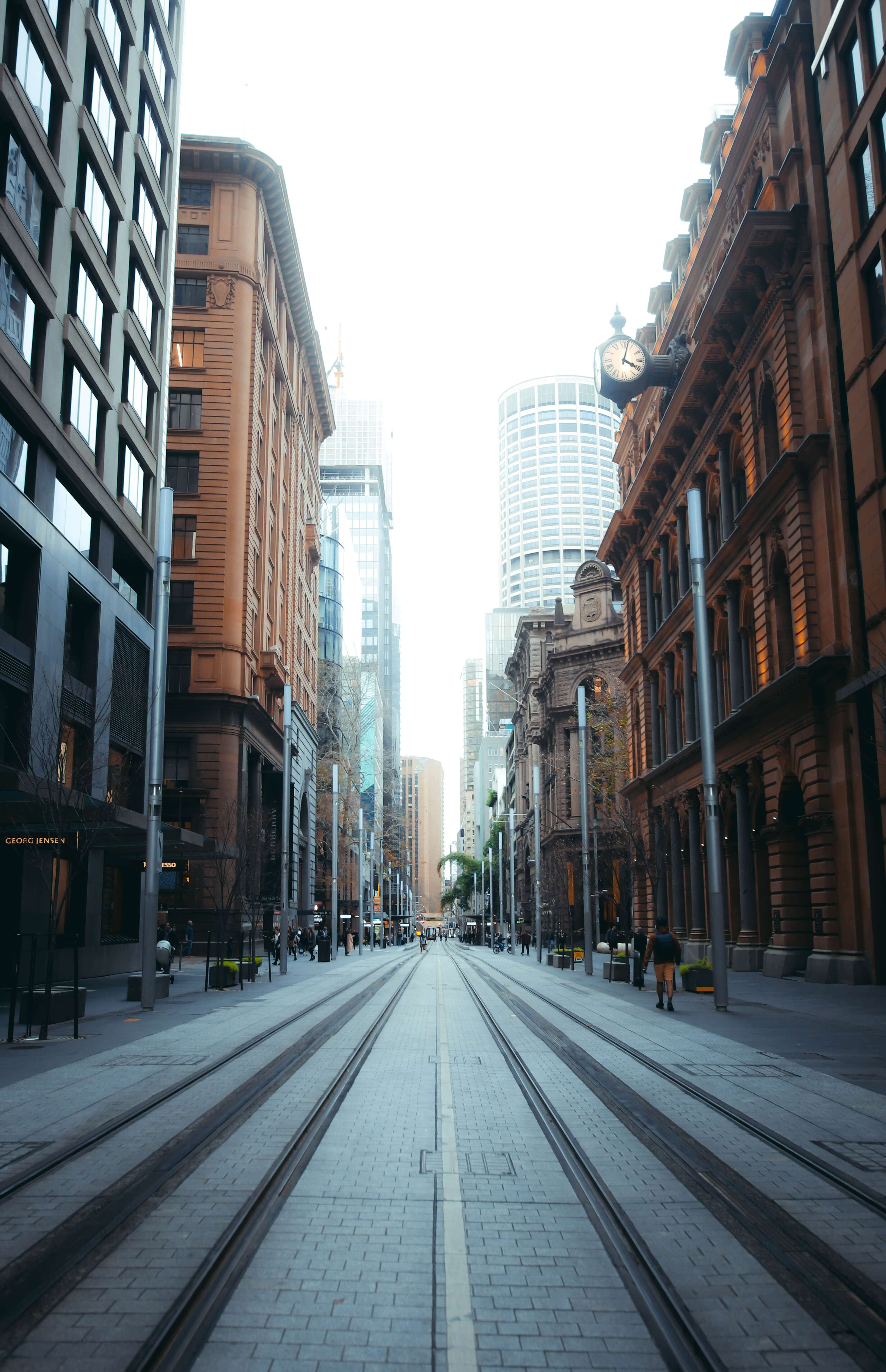 gray concrete road between high rise buildings during daytime